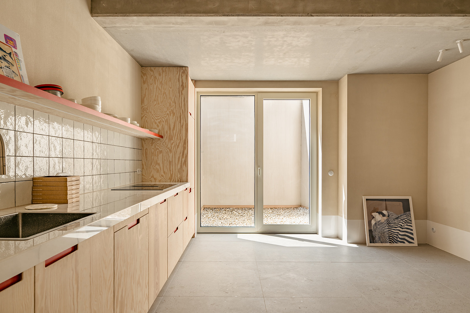 Kitchen with plywood cabinets and coral shelf