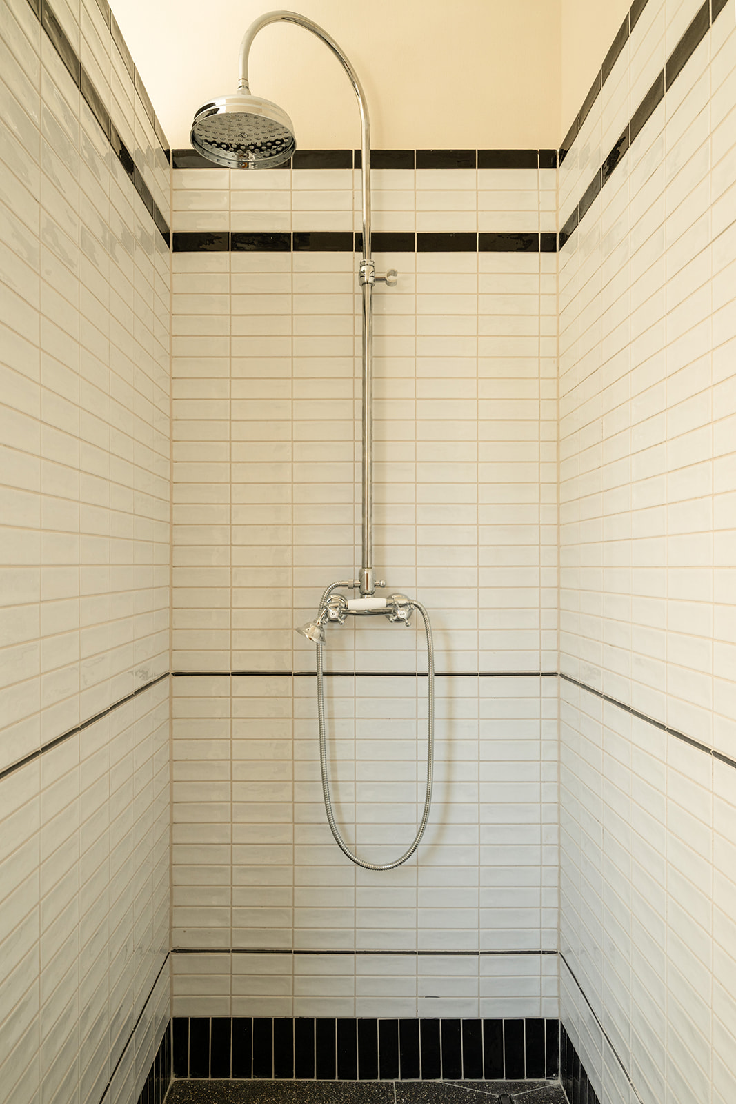 Shower with white and black striped tiles