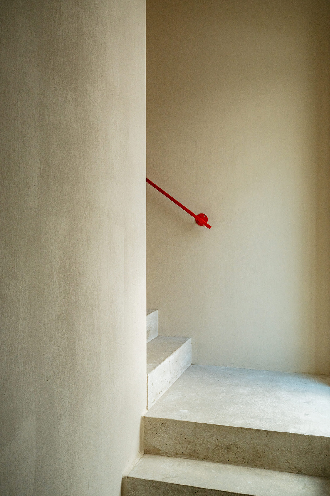 Concrete staircase with red handrail