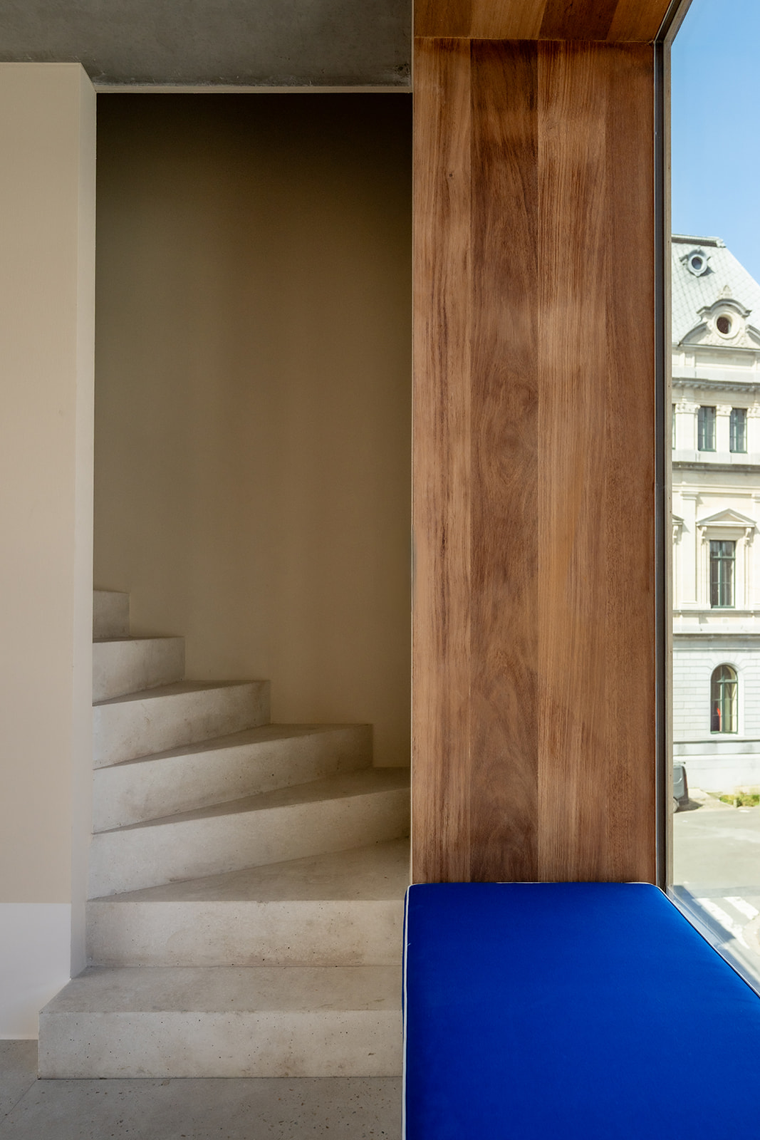 Wood-framed window next to concrete staircase